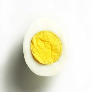 Half of a hard-boiled egg on a white plate.