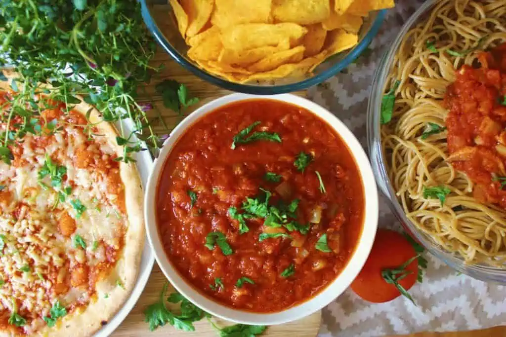 Tomato sauce in white bowl and garnished with parsley.