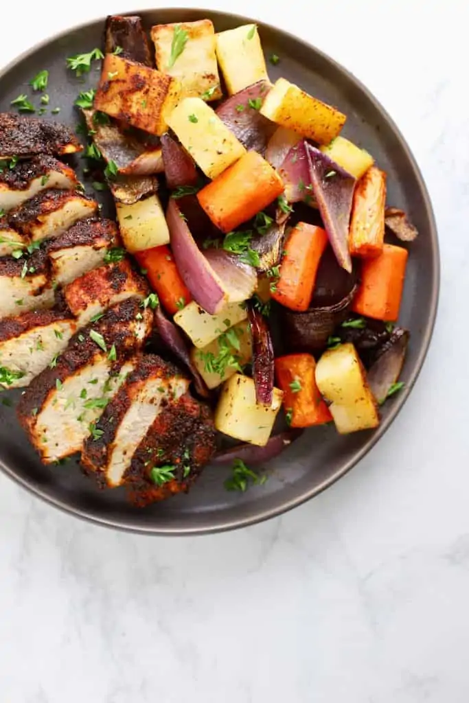 Chicken and vegetables on grey plate.