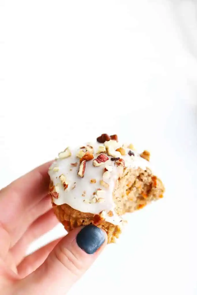 Healthy carrot cake muffin with a bite taken out of it.