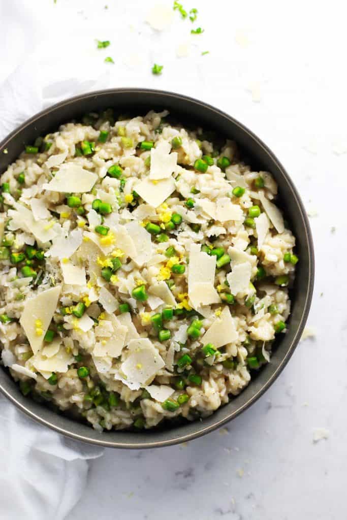 Lemon asparagus risotto in grey bowl with shaved parmesan. 