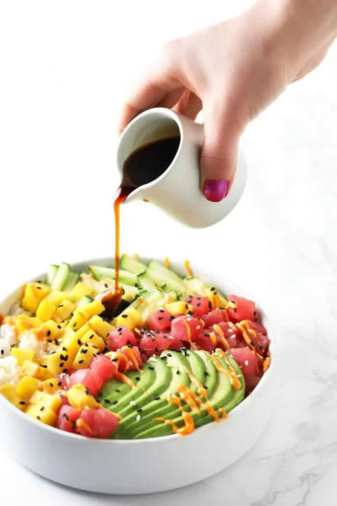 Pouring eel sauce over sushi bowl.