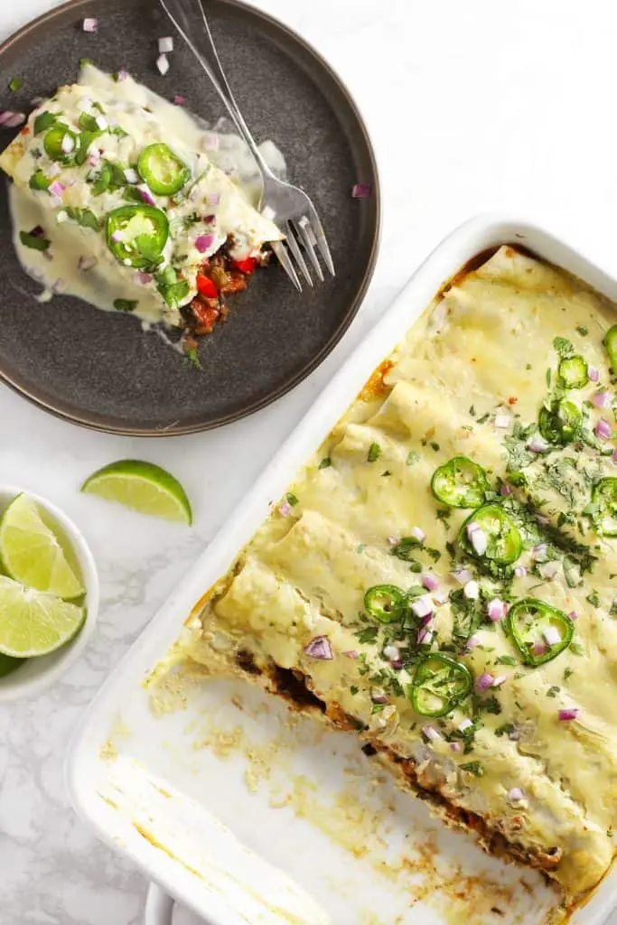 Vegetarian black bean enchiladas in a white dish.