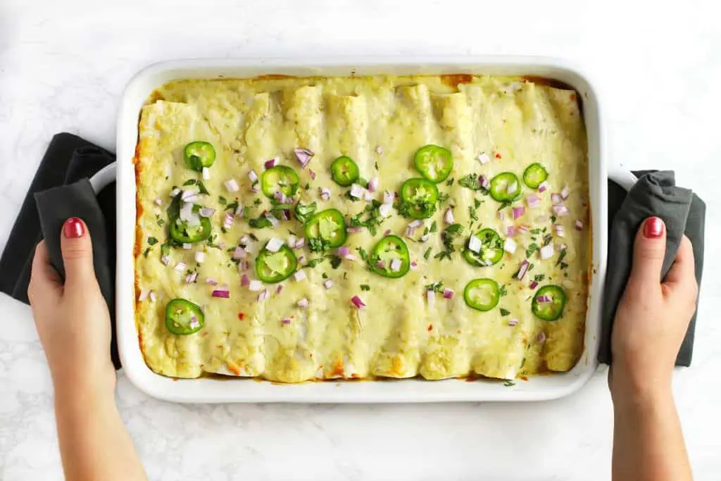 Vegetarian black bean enchiladas in a white dish.