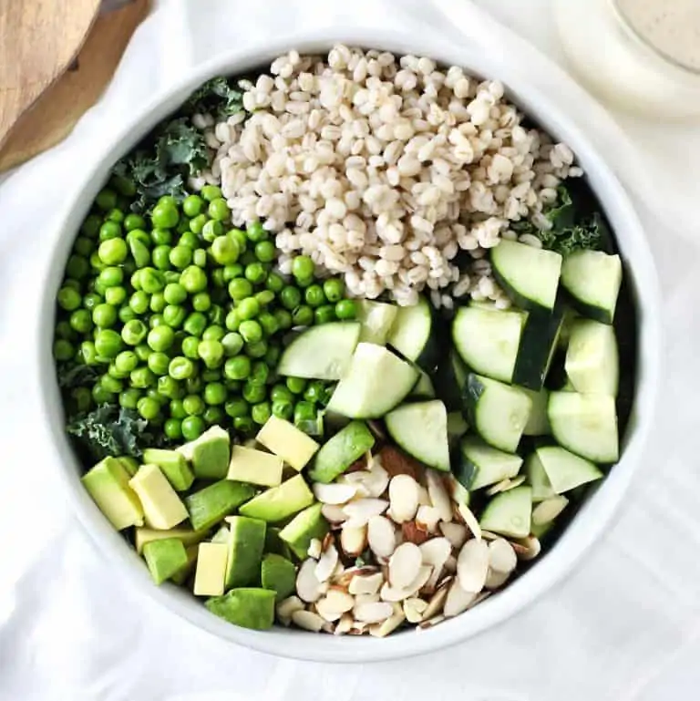 Green grain summer salad in white bowl.