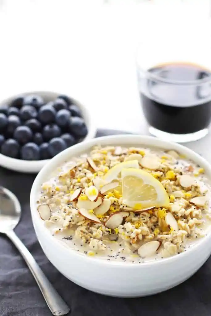 Lemon poppy seed overnight oats in a white bowl with grey napkin.