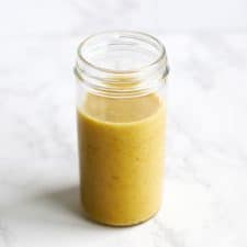 Roasted garlic vinaigrette in tall mason jar.