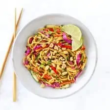 Thai noodle salad with peanut dressing with chopsticks in grey bowl.