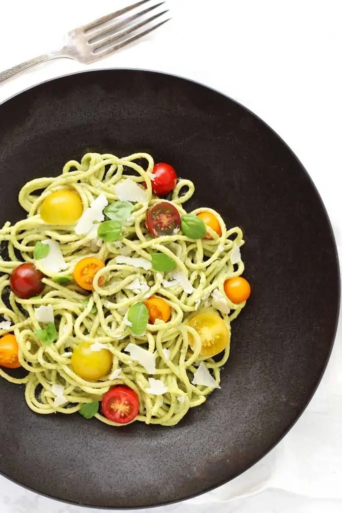 Creamy basil cashew pasta in black bowl.