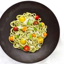 Creamy basil cashew pasta in black bowl.