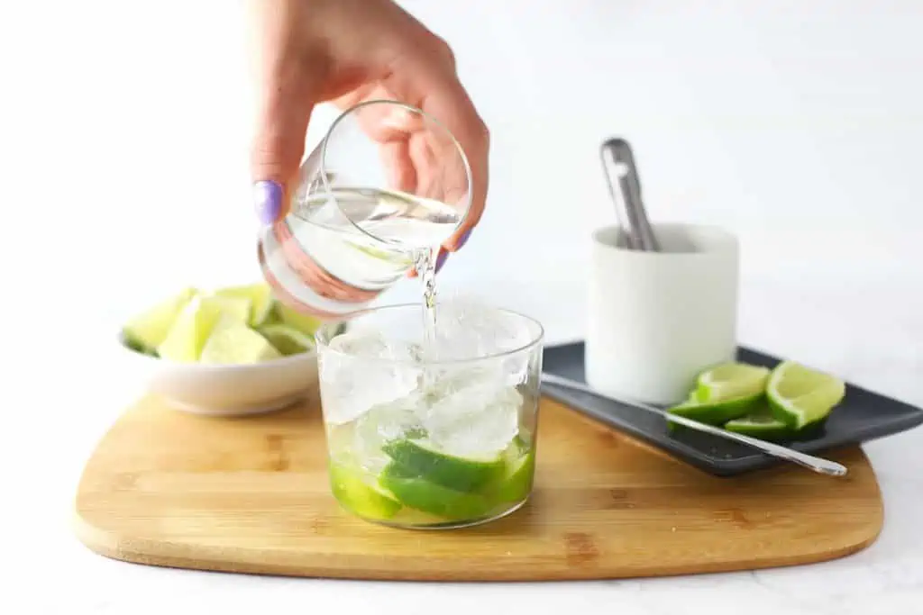 Pouring cachaca into a glass.