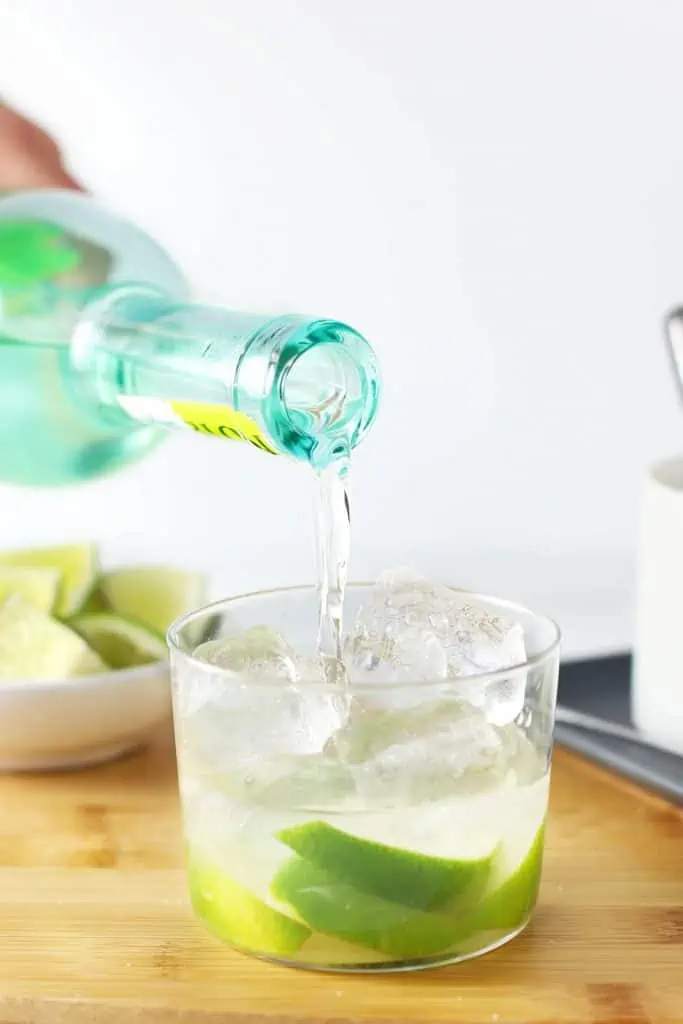 Pouring cachaca into a caipirinha.