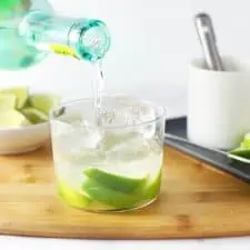 Pouring cachaca into a caipirinha.