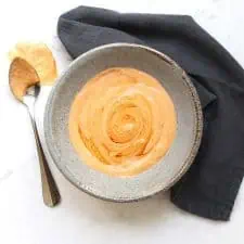 Chipotle aioli in grey bowl with spoon and grey napkin.