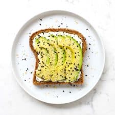 Everything bagel avocado toast on a white plate.