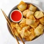 Cream cheese wontons on white plate.