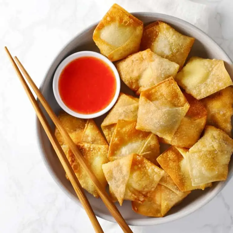 Cream cheese wontons on white plate.