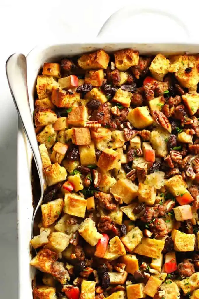 Italian sausage apple stuffing in white baking dish.