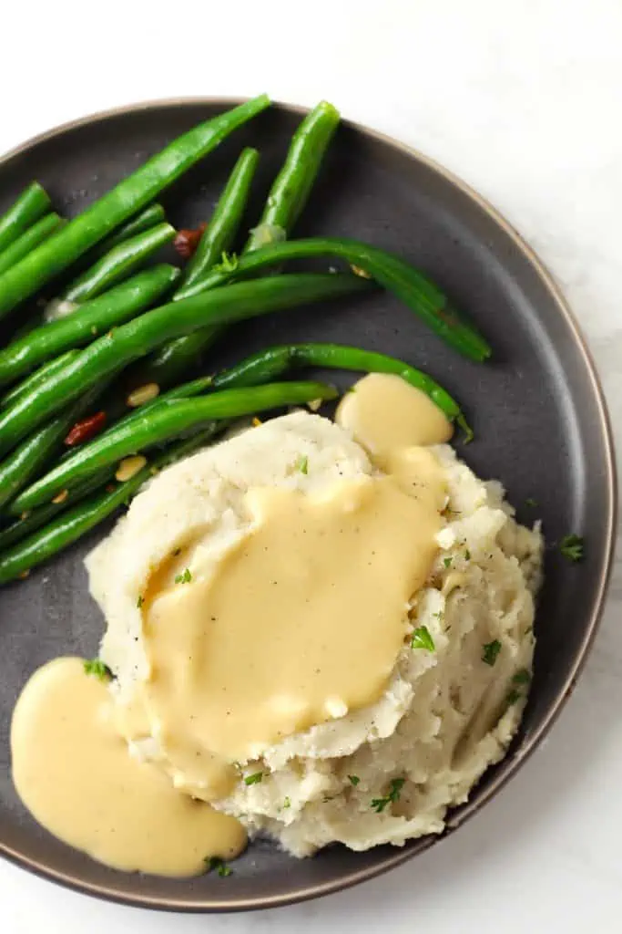 Mashed potatoes and gravy with green beans. 