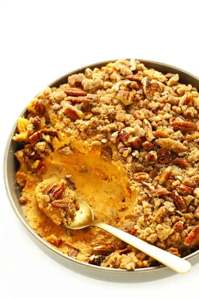slow cooker sweet potato casserole in grey bowl with gold spoon.
