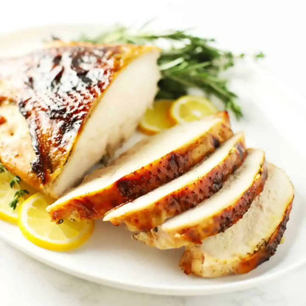 Roasted turkey breast on white platter.