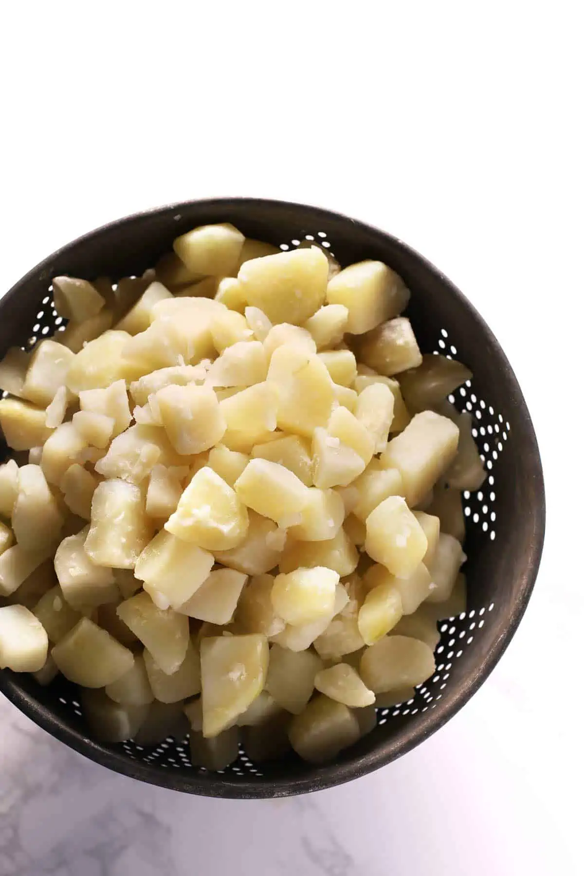 Boiled potatoes in a colander ready for mashing. 