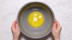 Partially melted butter in large bowl.