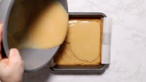 Pouring caramel on cookie layer.