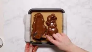 Spreading melted chocolate on cookie bars.