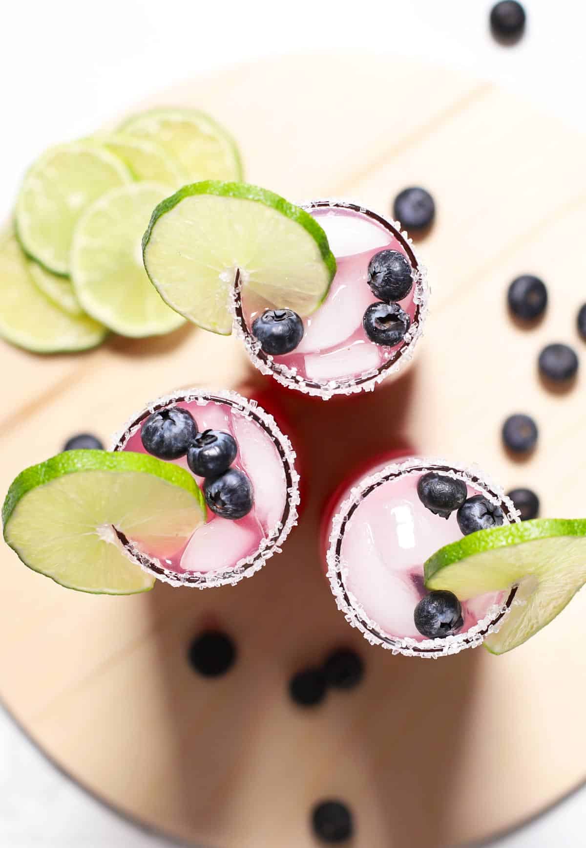 Overhead view of three blueberry margaritas. 