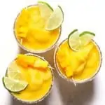 Three mango margaritas with lime.