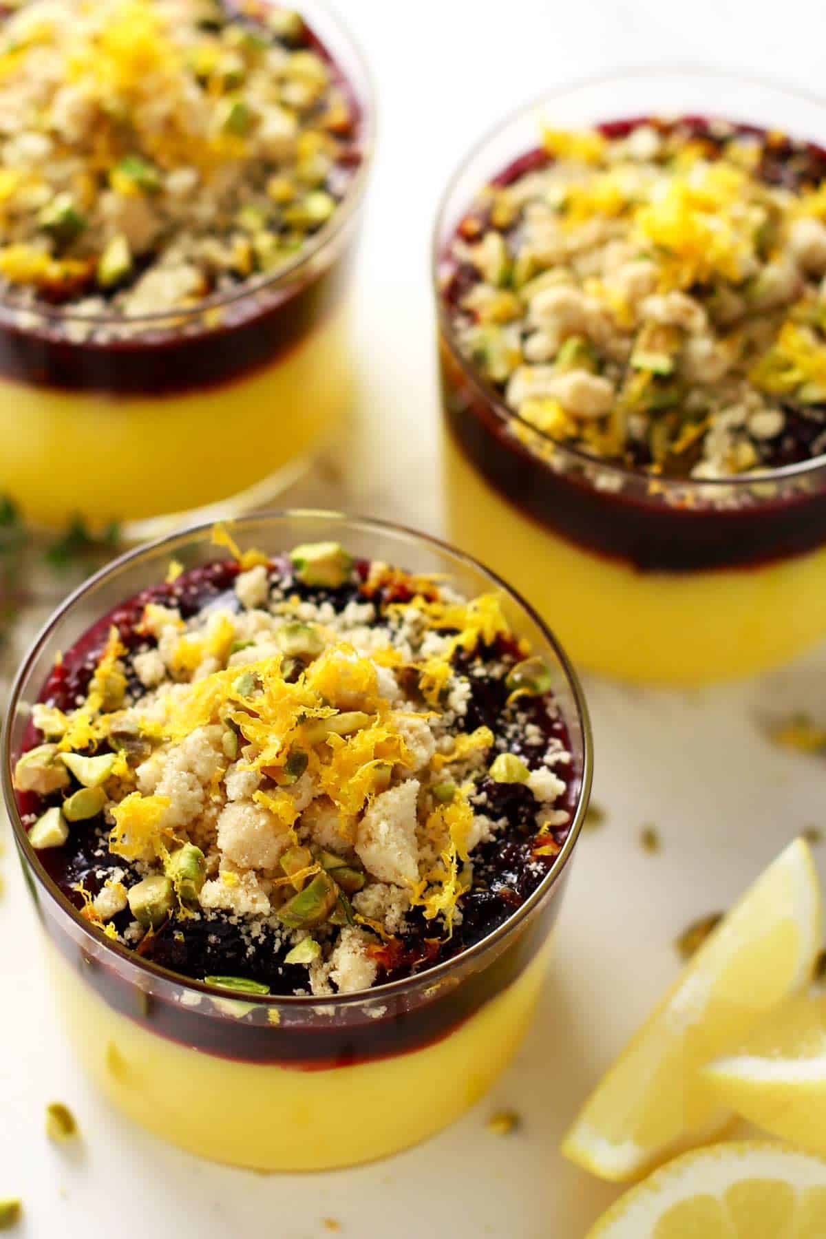 Lemon curd with cherry compote in a glass with shortbread crumble topping. 