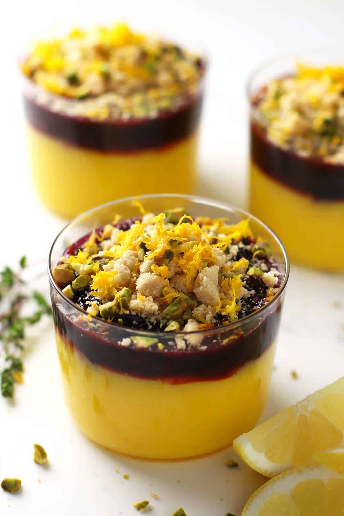 Lemon curd dessert topped with cherry compote and pistachios. 
