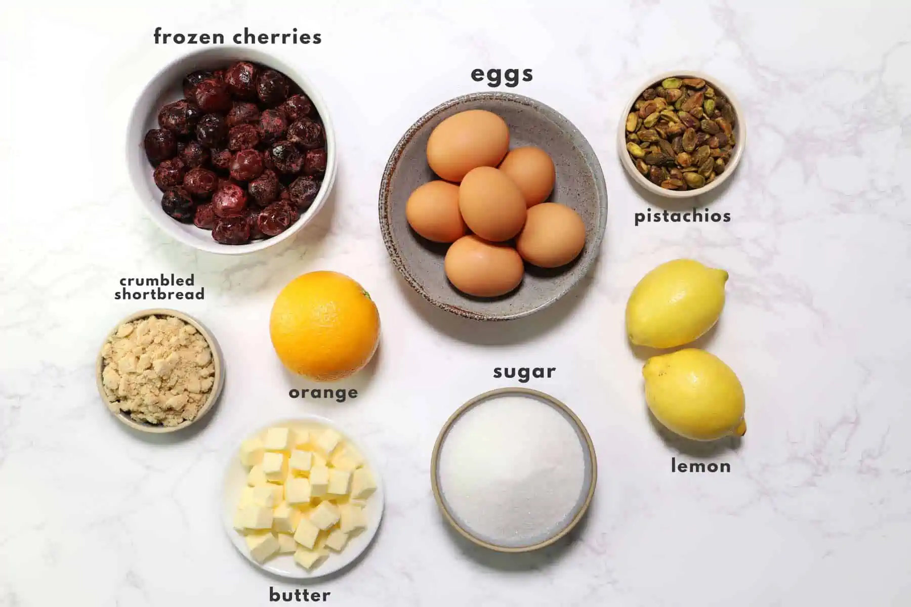 Ingredients to make lemon curd and cherry compote on a marble surface. 