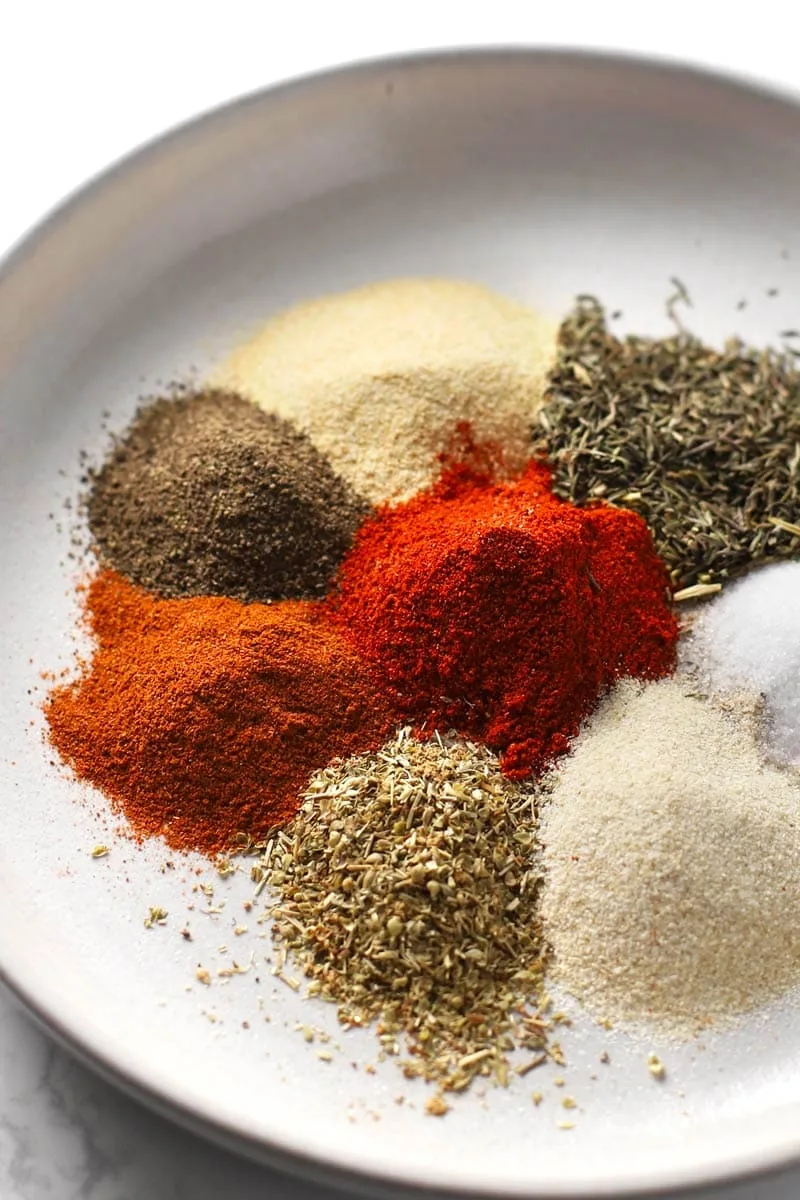 Cajun seasoning ingredients on a grey plate. 