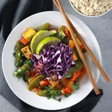 Coconut curry tofu in white bowl on grey surface.