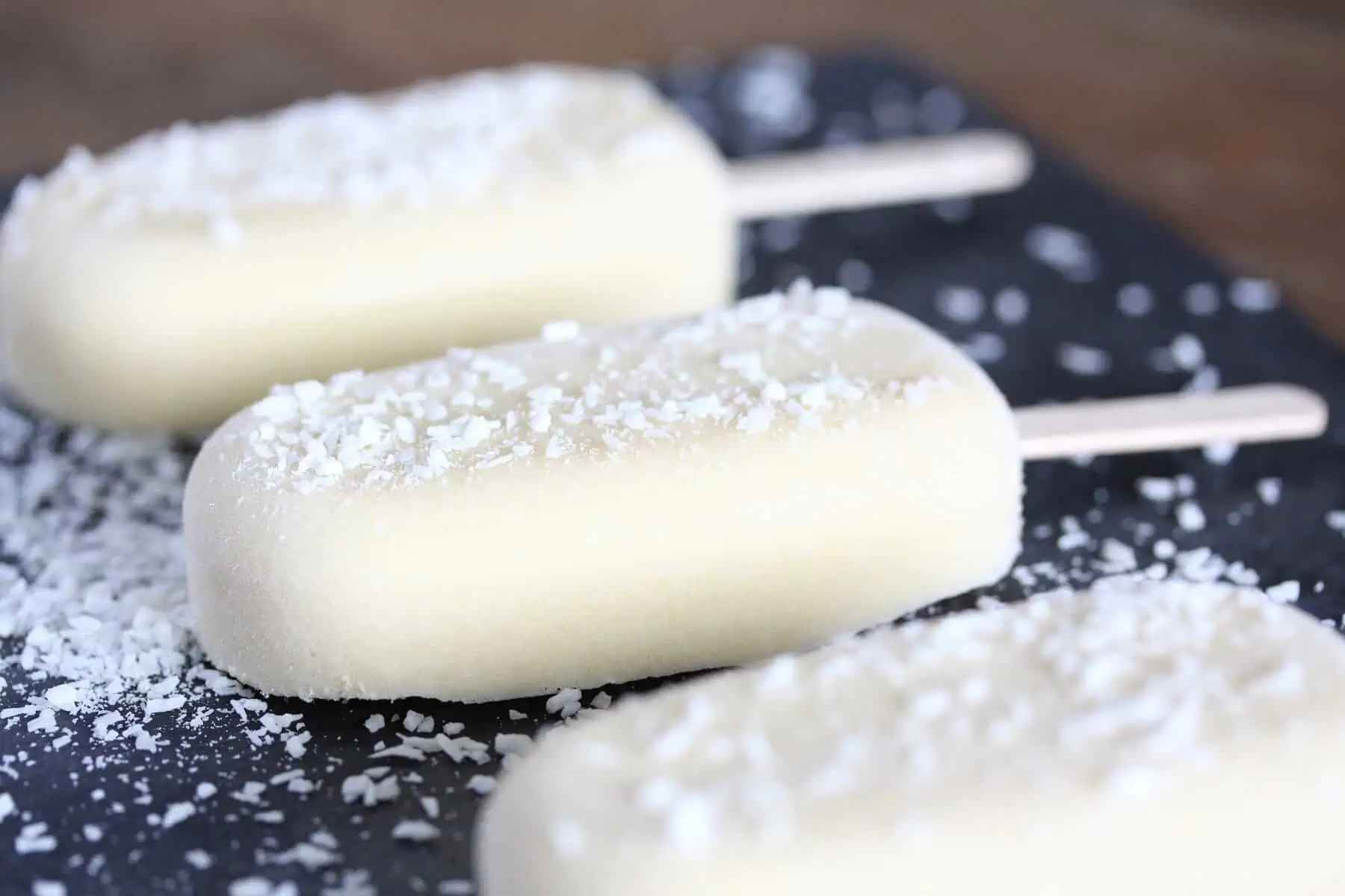 Three popsicles on grey serving platter.