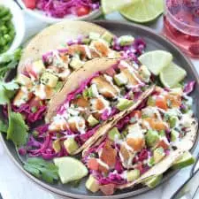 Three fish tacos on grey plate.