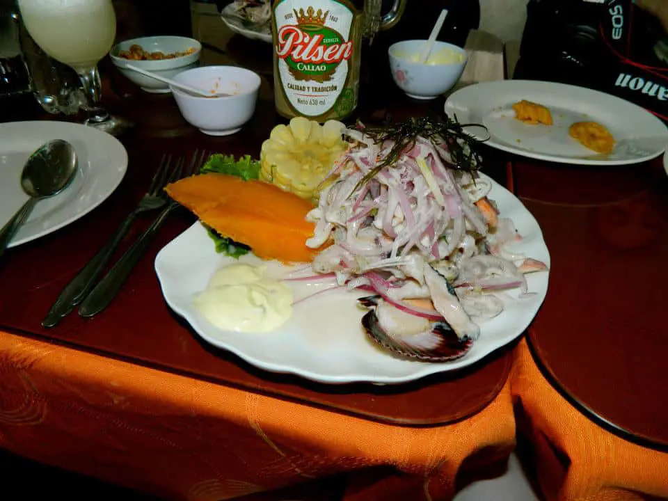 Fish salad and sweet potato on white plate.