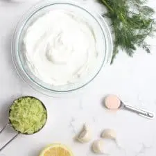 Yogurt, cucumber, lemon dill and garlic on marble surface.