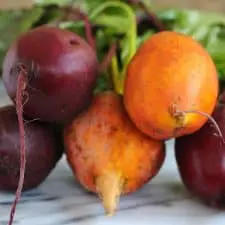 Raw beets on marble cutting board.