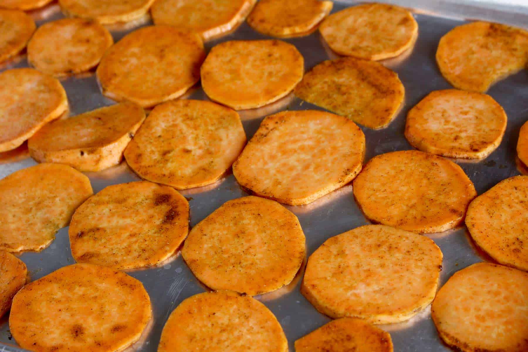 Sliced sweet potato on sheet pan.