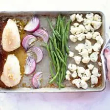 Onions, beans, cauliflower and chicken on sheet pan.