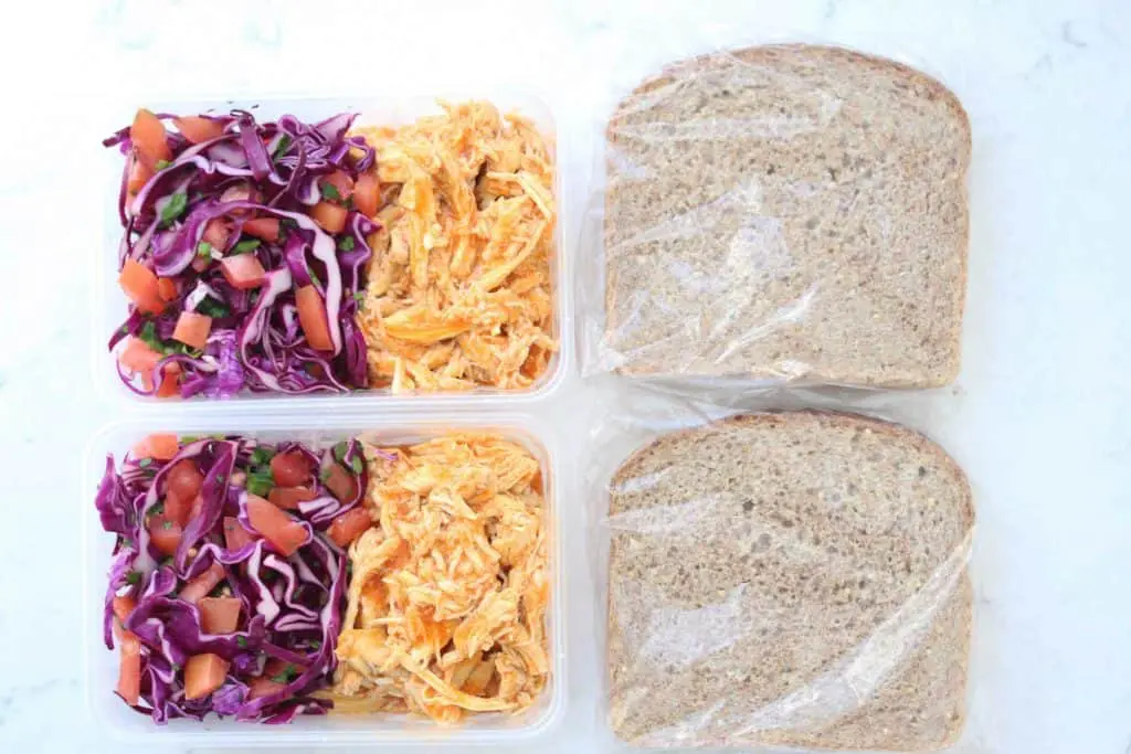 Vegetables and chicken in plastic containers next to slices of bread.