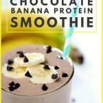 Chocolate smoothie with banana slices in clear glass on white surface.