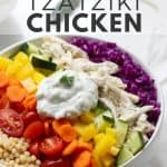 Fresh veggies, couscous and chicken in white bowl with Tzatziki sauce.