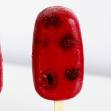 Red popsicle on white background.
