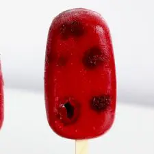 Red popsicle on white background.