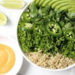 Greens and quinoa in white bowl.