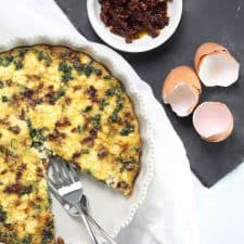 Quiche in white dish with two forks.